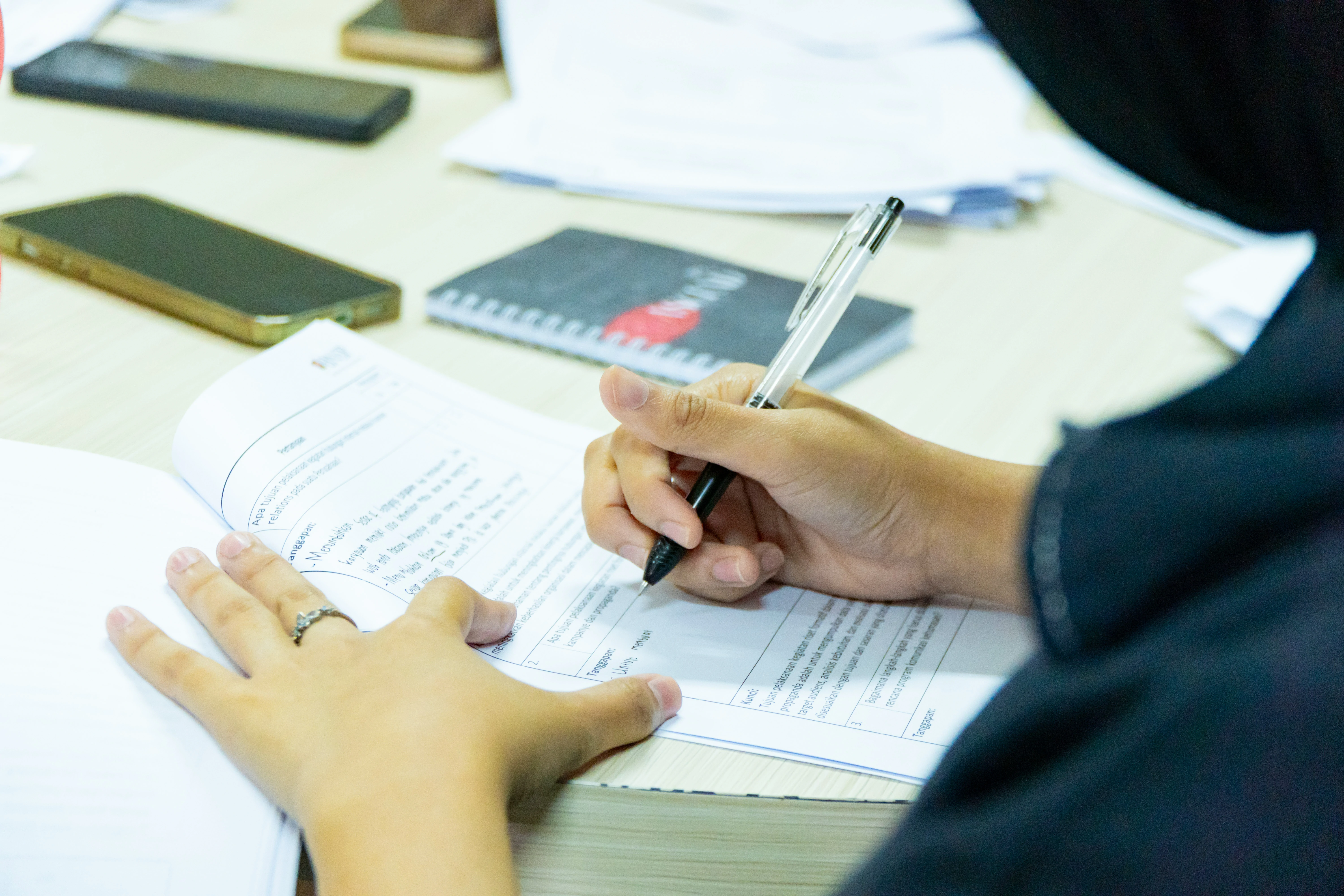 Seseorang sedang menulis di buku catatan